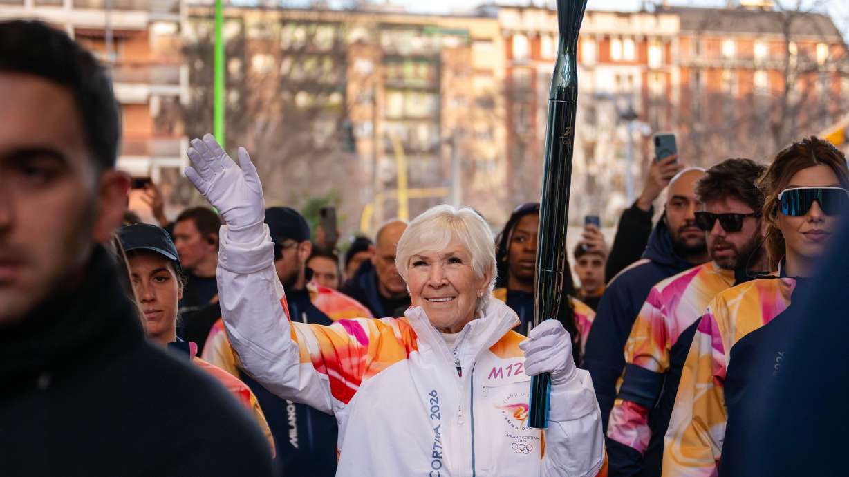 Gail Miller waves as she carries the Olympic flame into the CityLife Shopping District during the 2026 Milan Cortina Winter Games torch run in Milan, Italy, on Feb. 5. Miller was recently named as one of Forbes' 250 Greatest Self-Made Americans.