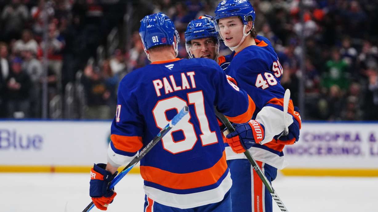 New York Islanders' Matthew Schaefer (48) celebrates with teammates Tony DeAngelo (77) andn Ondrej Palat (81) after scoring a goal during the second period of an NHL hockey game against the Toronto Maple Leafs Thursday, April 9, 2026, in Elmont, N.Y.