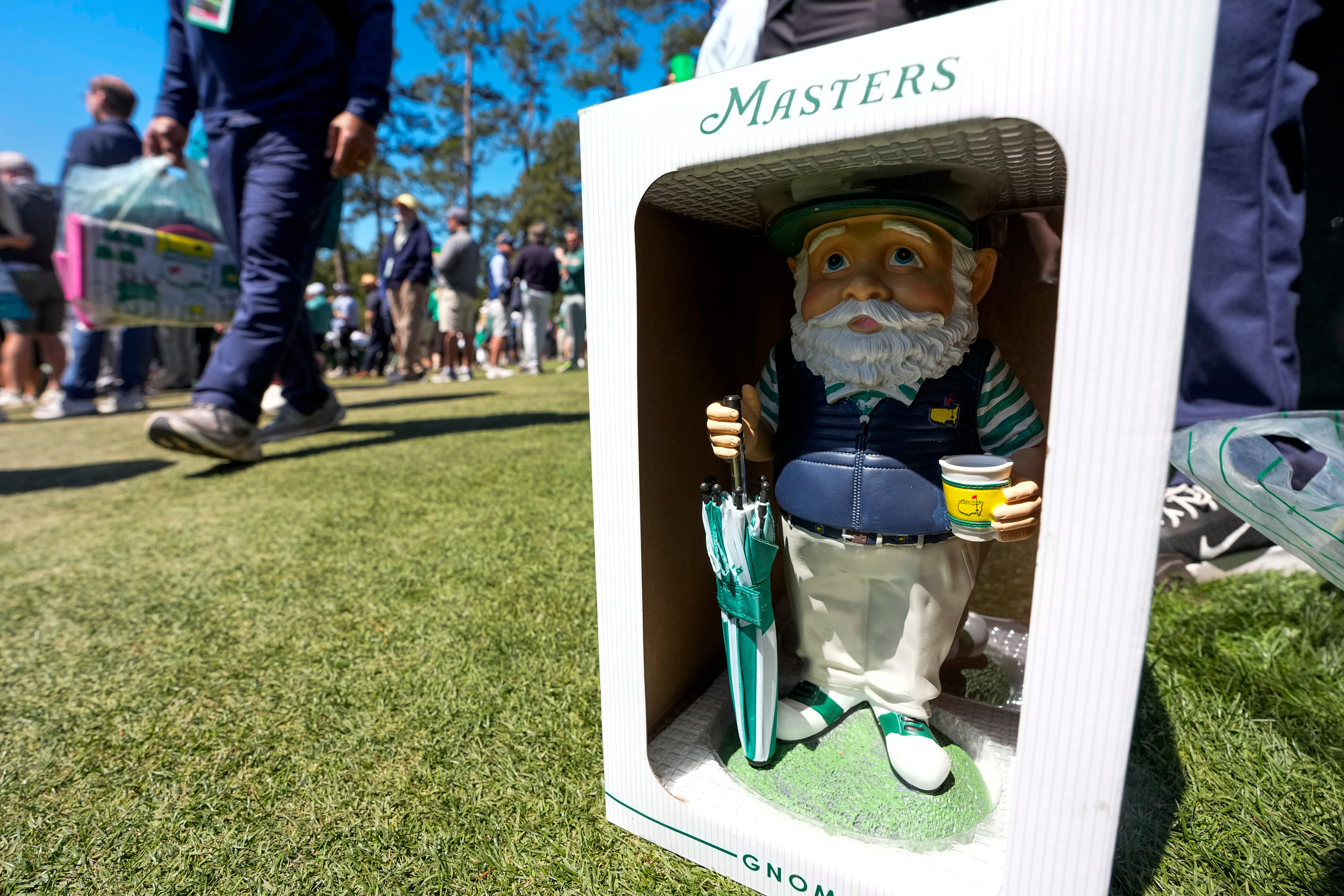 Patrons walk past this years gnome on the 12th hole during the first round of the Masters golf tournament at the Augusta National Golf Club, Thursday, April 9, 2026, in Augusta, Ga. 