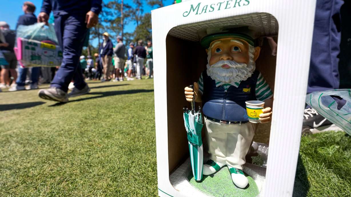 Patrons walk past this years gnome on the 12th hole during the first round of the Masters golf tournament at the Augusta National Golf Club, Thursday, April 9, 2026, in Augusta, Ga.