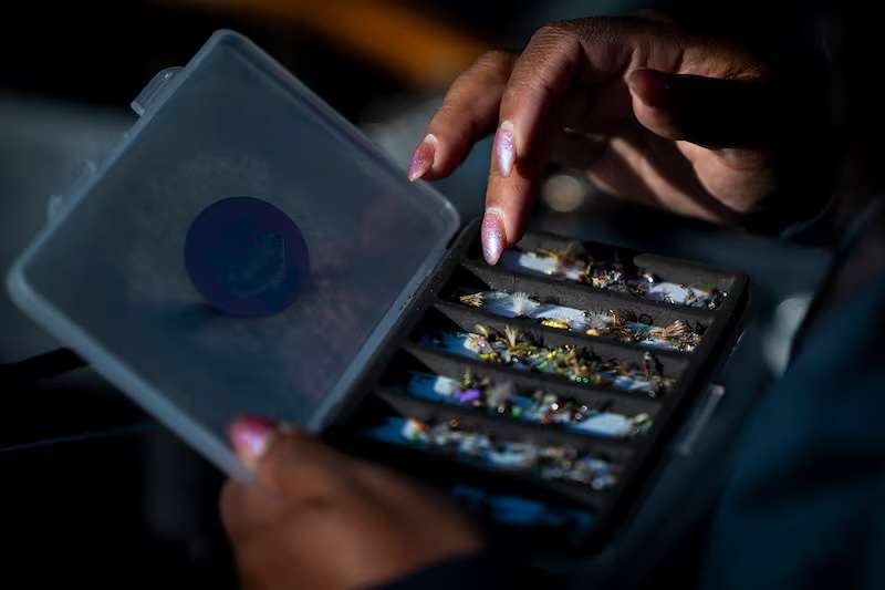 Rebeca Granillo, a fly-fishing instructor from Millcreek, looks through flies as she readies equipment at her car near the Provo River in Charleston on Wednesday.