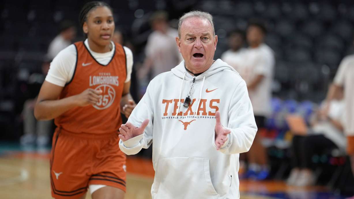 Texas head coach Vic Schaefer, right, encourages his players at Texas forward Madison Booker (35) runs the court during practice prior to the national semifinals Women's Final Four of the NCAA college basketball tournament, Thursday, April 2, 2026, in Phoenix.
