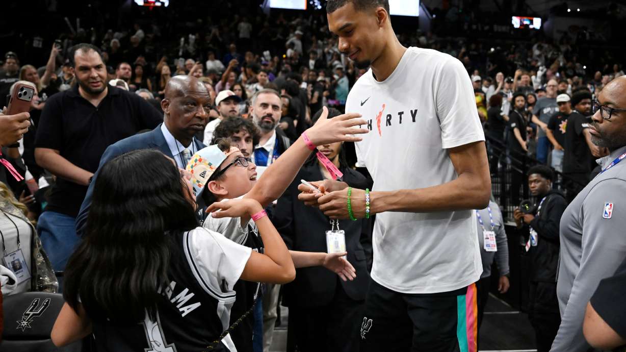 San Antonio Spurs center Victor Wembanyama, center right, greets fans after an NBA basketball game against the Dallas Mavericks, Friday, April 10, 2026, in San Antonio.