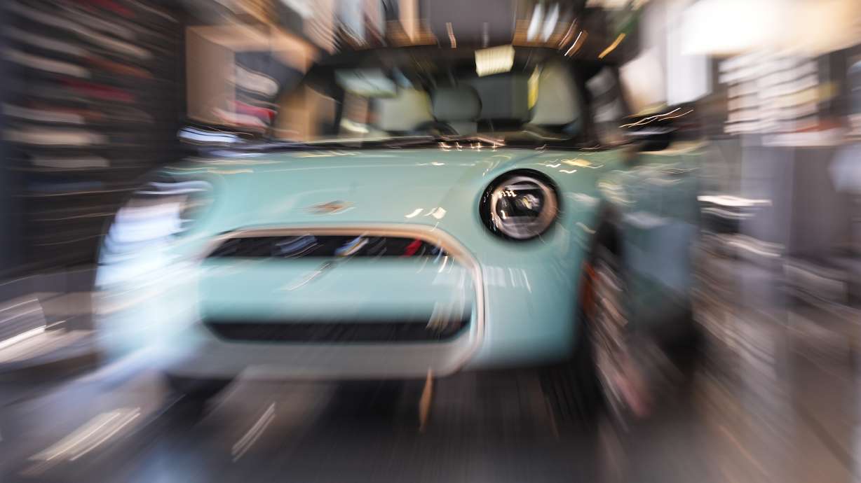 Made with a slow shutter speed and zoom lens, an unsold 2026 Cooper S hardtop is displayed in a Mini dealership Friday, Oct. 24, 2025, in Highlands Ranch, Colo.