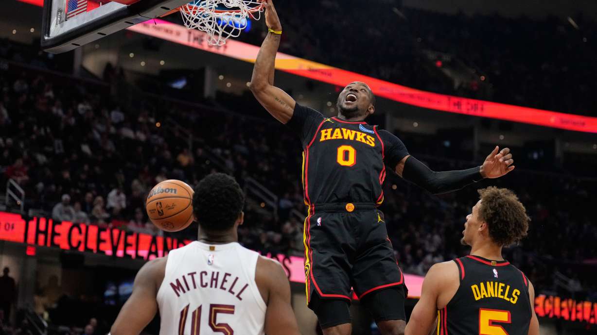 Atlanta Hawks forward Jonathan Kuminga (0) dunks in front of Cleveland Cavaliers guard Donovan Mitchell (45) and teammate Dyson Daniels (5) in the second half of an NBA basketball game in Cleveland, Wednesday, April 8, 2026.