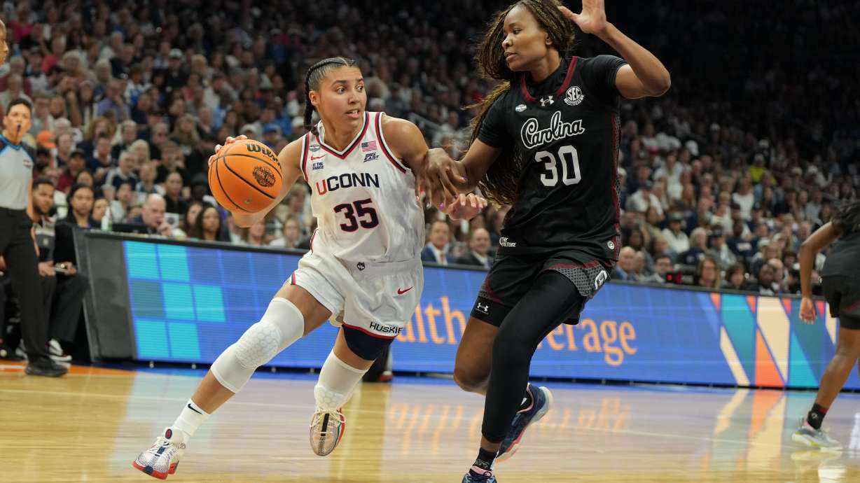 UConn guard Azzi Fudd (35) drives against South Carolina forward Maryam Dauda (30) during the first half of a woman's NCAA college basketball tournament semifinal game at the Final Four, Friday, April 3, 2026, in Phoenix.