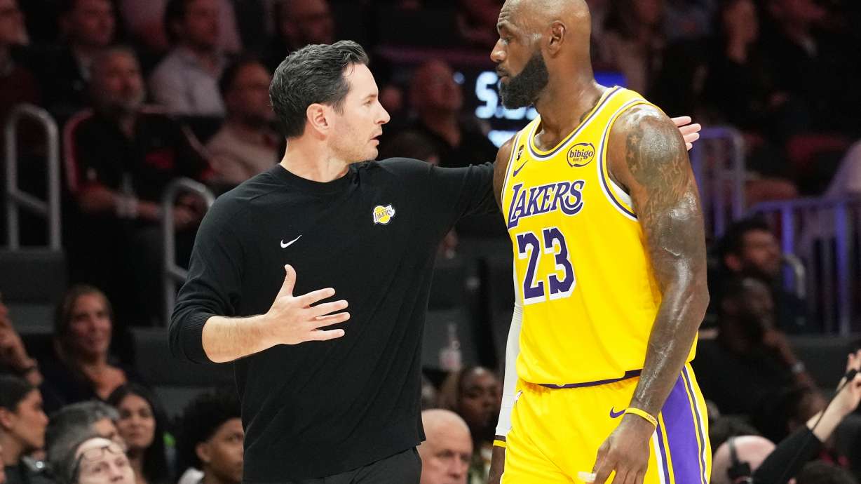 Los Angeles Lakers head coach JJ Redick, left, talks with forward LeBron James (23) during the second half of an NBA basketball game against the Miami Heat, Thursday, March 19, 2026, in Miami.