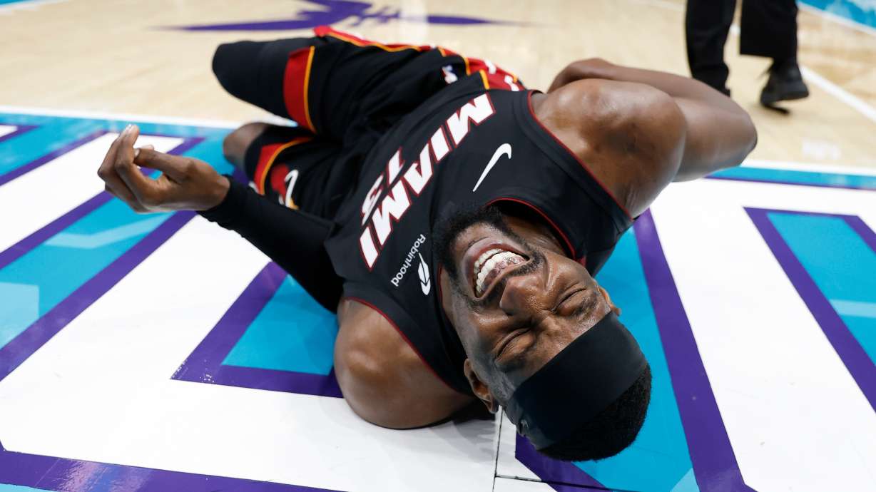 Miami Heat center Bam Adebayo (13) lies on the court during the first half of an NBA play-in tournament basketball game against the Charlotte Hornets in Charlotte, N.C., Tuesday, April 14, 2026.