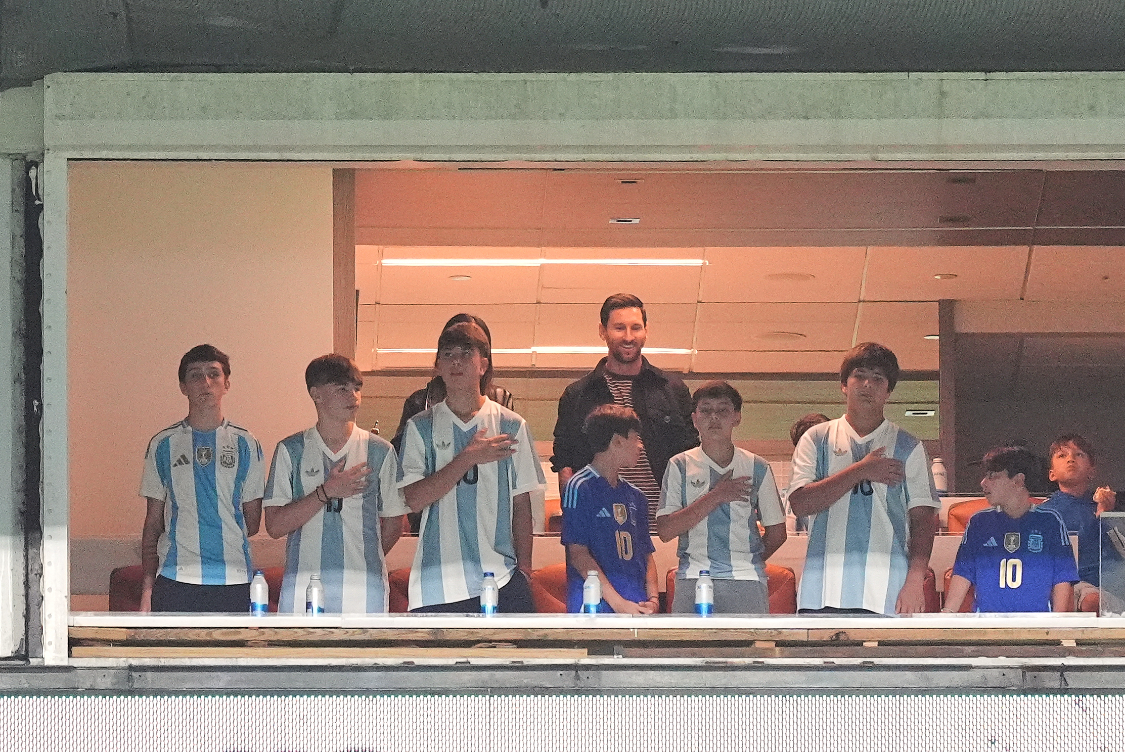 FILE - Argentina forward Lionel Messi, center top, watches from a box with family and friends at the start of an international friendly soccer match between Venezuela and Argentina, Oct. 10, 2025, in Miami Gardens, Fla.