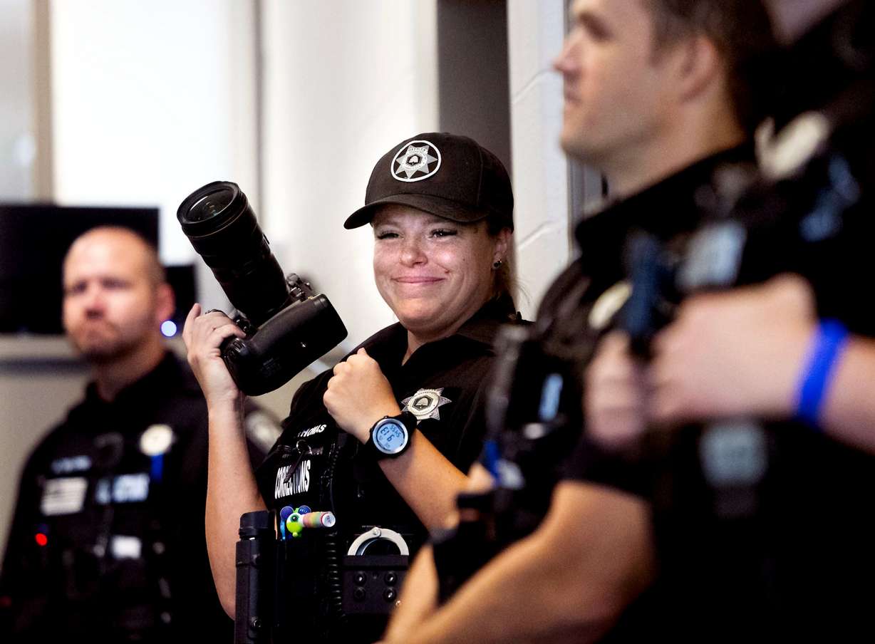 Corrections officer Natalie Thomas photographs graduates of the Ensign College Prison Education Program at the Utah State Correctional Facility in Salt Lake City on Wednesday. School President Bruce C. Kusch called the ceremony an unforgettable day.