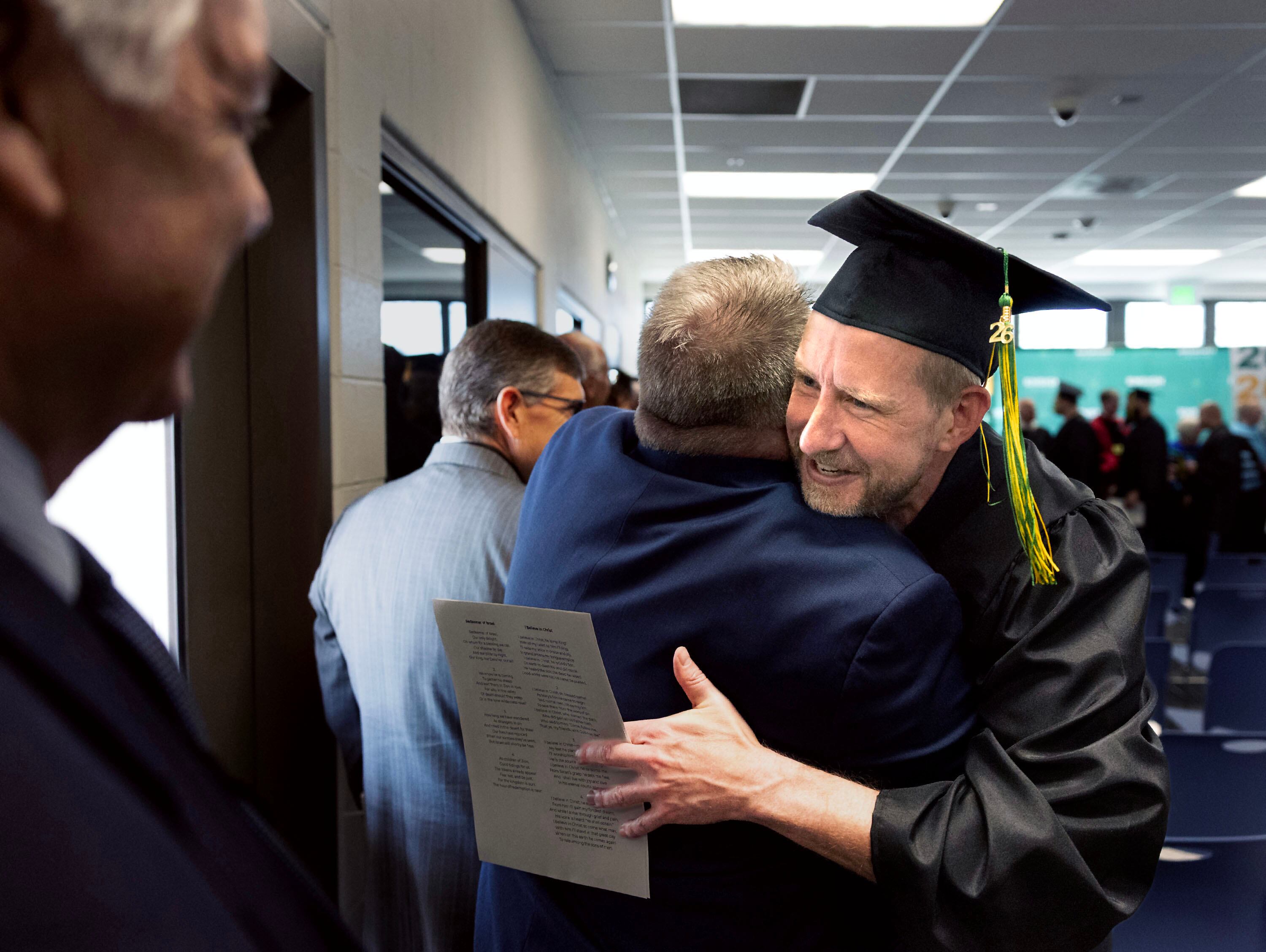 Michael is congratulated by one of his adjunct professors after receiving a graduation certificate from the Ensign College Prison Education Program at the Utah State Correctional Facility in Salt Lake City on Wednesday. The ceremony was the first held off-campus in school history.