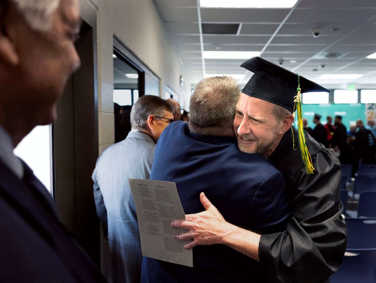 Michael is congratulated by one of his adjunct professors after receiving a graduation certificate from the Ensign College Prison Education Program at the Utah State Correctional Facility in Salt Lake City on Wednesday. The ceremony was the first held off-campus in school history.
