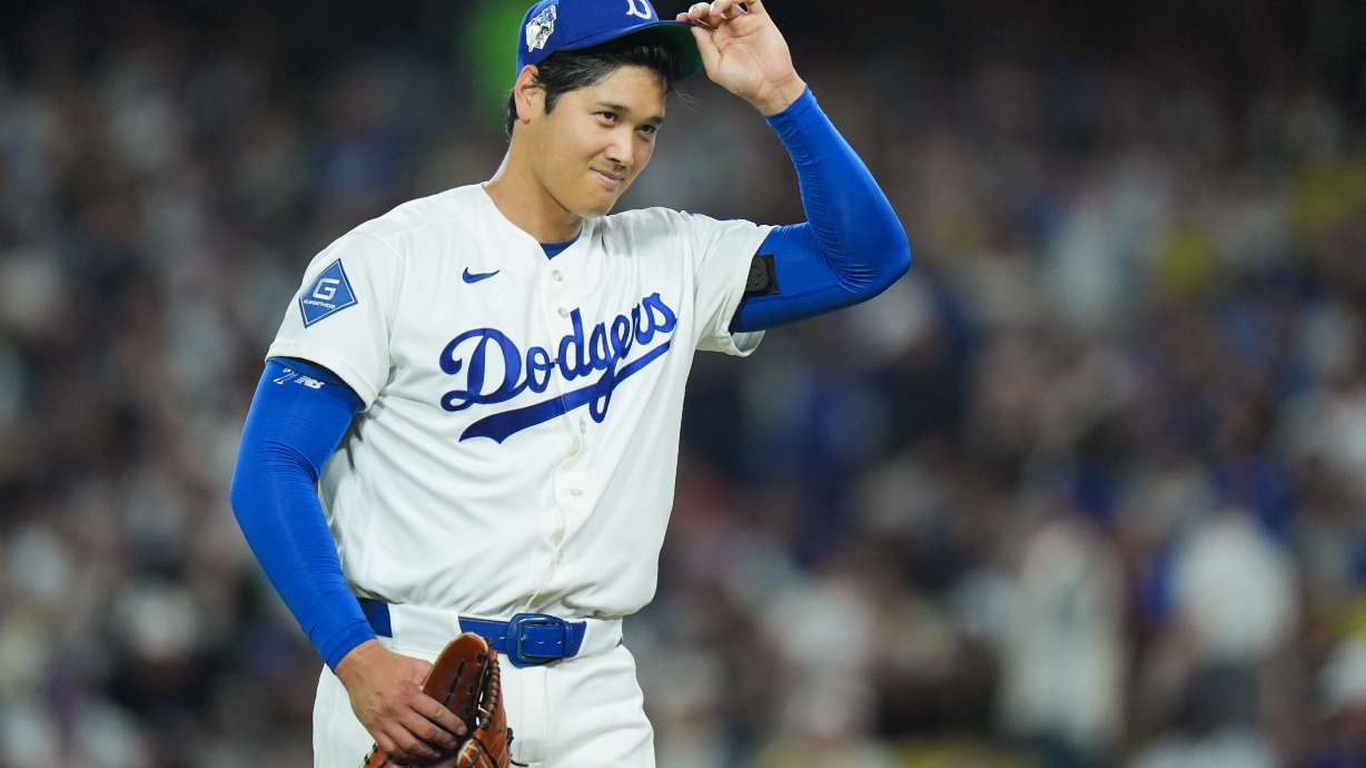Los Angeles Dodgers starting pitcher Shohei Ohtani adjusts his hat as he walks off the field after the third inning of a baseball game against the New York Mets Wednesday, April 15, 2026, in Los Angeles.