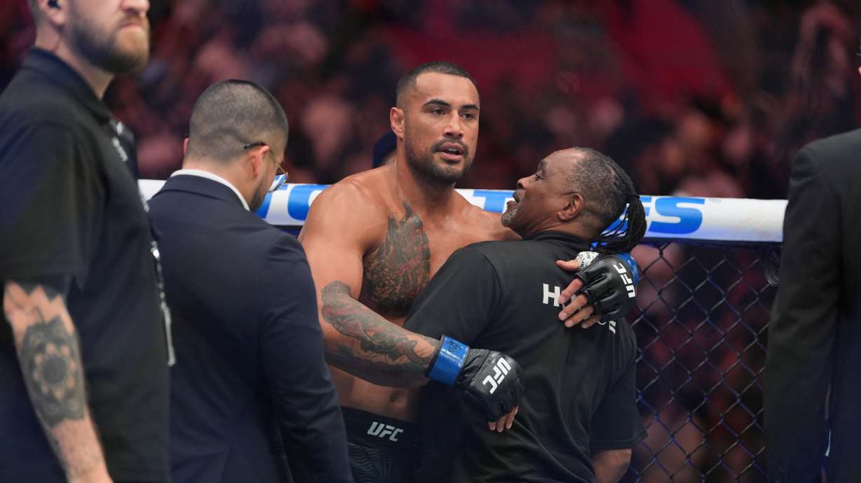Carlos Ulberg, center, of New Zealand, reacts after defeating Jiri Prochazka, of Czechia, by TKO to win their light heavyweight title bout at a UFC 327 mixed martial arts event, Saturday, April 11, 2026, in Miami.