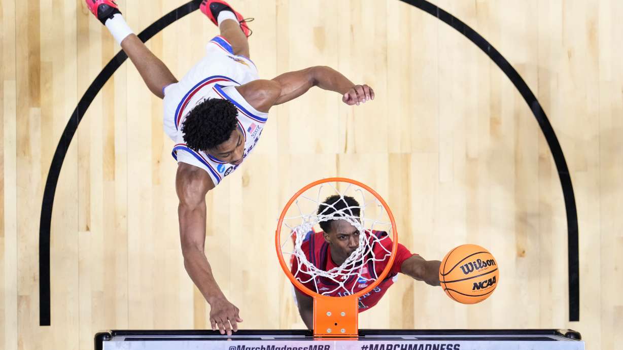 St. John's guard Ian Jackson (11) shoots around Kansas forward Bryson Tiller (15) during a game in the second round of the NCAA college basketball tournament Sunday, March 22, 2026, in San Diego.