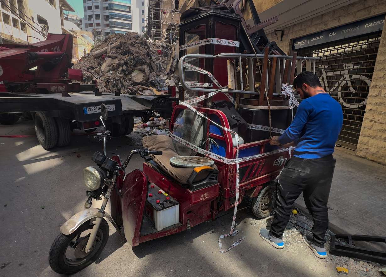 A worker arranges furniture from an apartment of a destroyed building that was hit a week ago in an Israeli airstrike in central Beirut, Lebanon, Thursday.