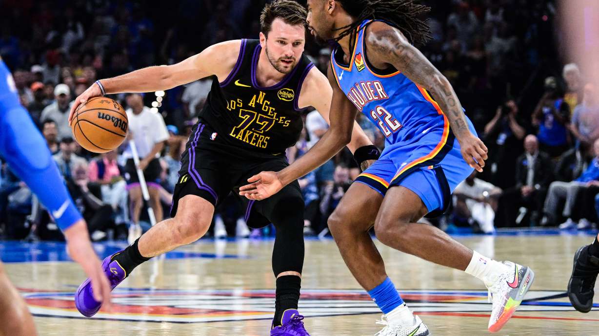 Los Angeles Lakers forward/guard Luka Dončić (77) drives against Oklahoma City Thunder guard Cason Wallace (22) during the first half of an NBA basketball game Thursday, April. 2, 2026, in Oklahoma City.