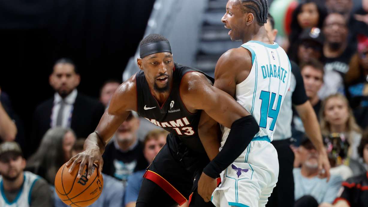 Miami Heat center Bam Adebayo, left, drives against Charlotte Hornets forward Moussa Diabate during the first half of an NBA play-in tournament basketball game in Charlotte, N.C., Tuesday, April 14, 2026.