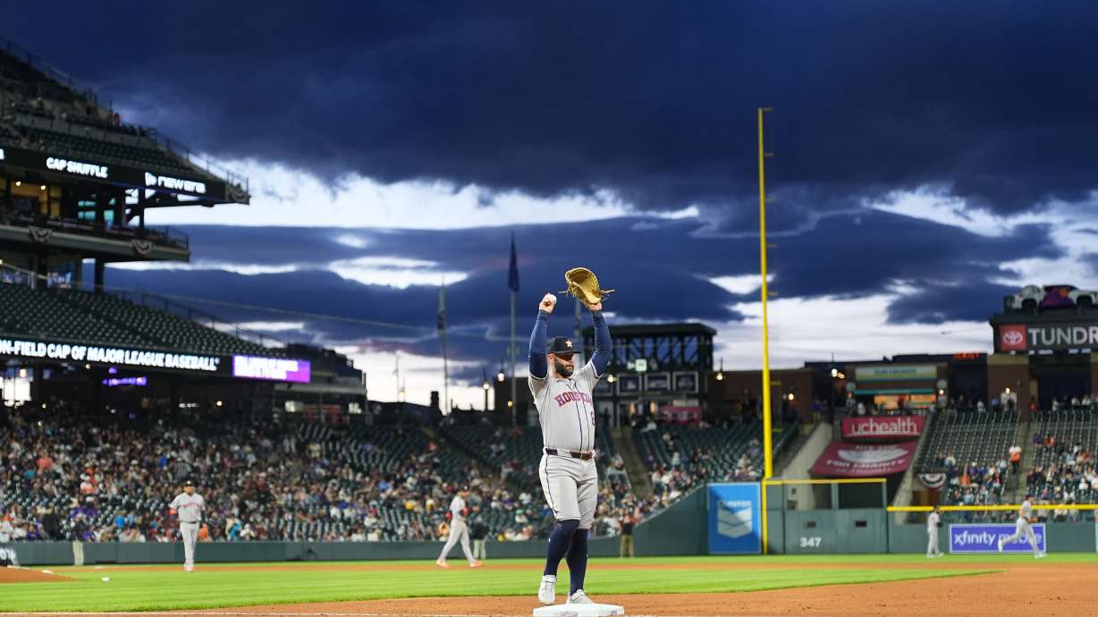 Houston Astros first baseman Christian Walker stretches as he takes his position while clouds roll in over Coors Field in the fourth inning of a baseball game against the Colorado Rockies Tuesday, April 7, 2026, in Denver.