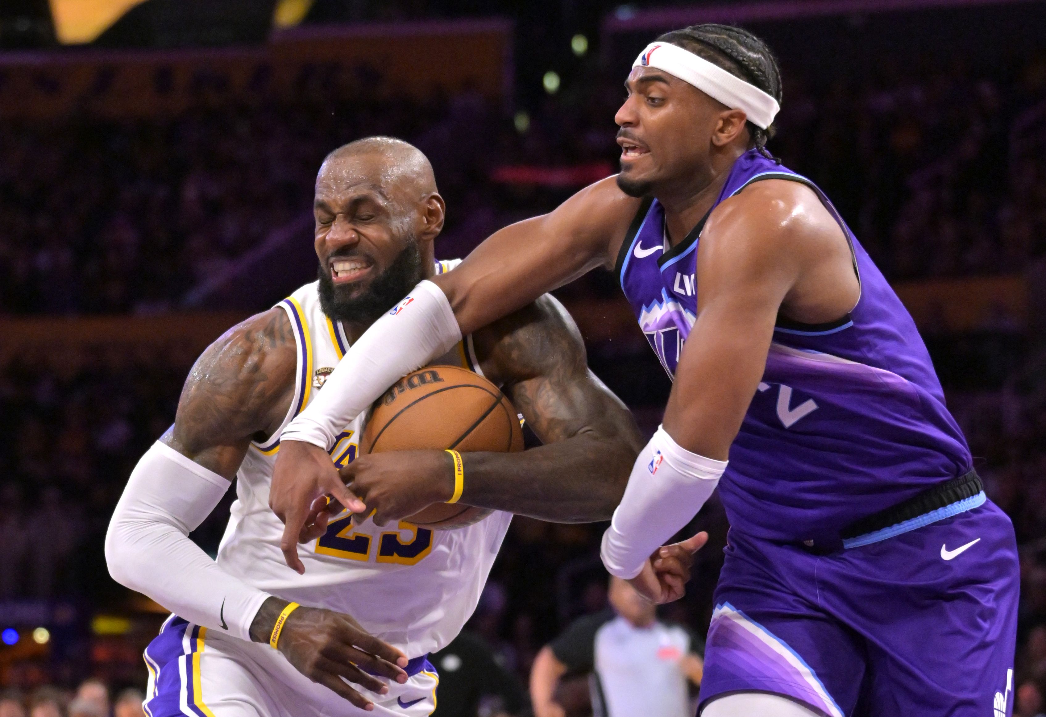 Los Angeles Lakers forward LeBron James, left, is fouled by Utah Jazz forward Blake Hinson (2) as he drives to the basket during the first half of an NBA basketball game Sunday, April 12, 2026, in Los Angeles. 