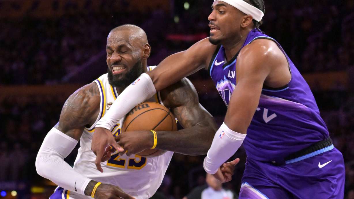Los Angeles Lakers forward LeBron James, left, is fouled by Utah Jazz forward Blake Hinson (2) as he drives to the basket during the first half of an NBA basketball game Sunday, April 12, 2026, in Los Angeles.