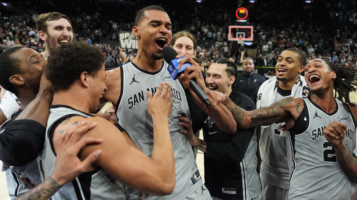 San Antonio Spurs forward Victor Wembanyama, center, celebrates with teammates after he hit a game-winning score against the Phoenix Suns in the final seconds of an NBA basketball game in San Antonio, Thursday, March 19, 2026.