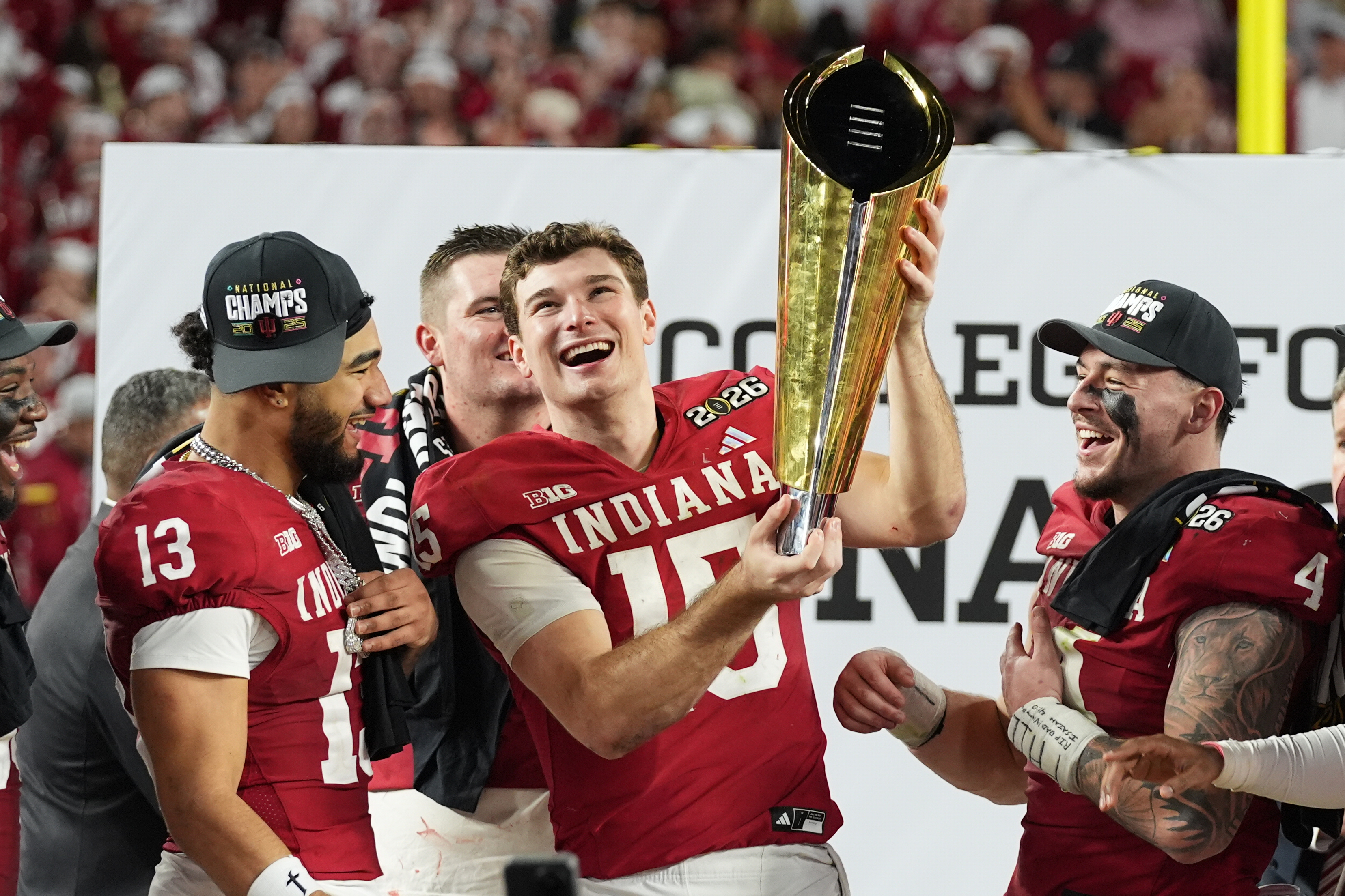 FILE - Indiana quarterback Fernando Mendoza holds the trophy after Indiana defeated Miami in a College Football Playoff national championship game in Miami Gardens, Fla., Jan. 19, 2026, 