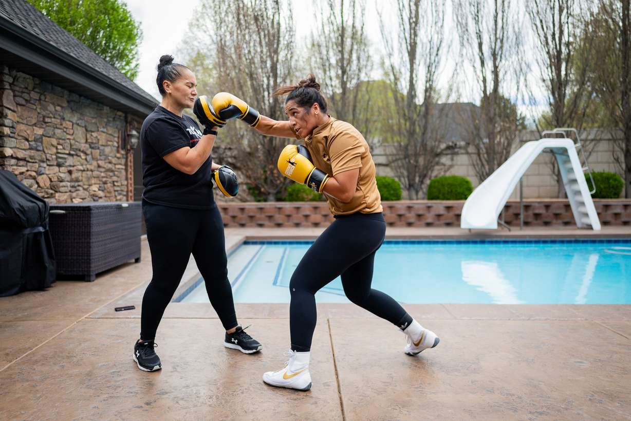 World boxing champion Lani Daniels, a member of The Church of Jesus Christ of Latter-day Saints, trains with her sister, Caroline Daniels, at her friend Caroline Kreutzkamp’s home in Orem on April 10. Daniels found comfort inside the ropes of the sport after her younger brother died.