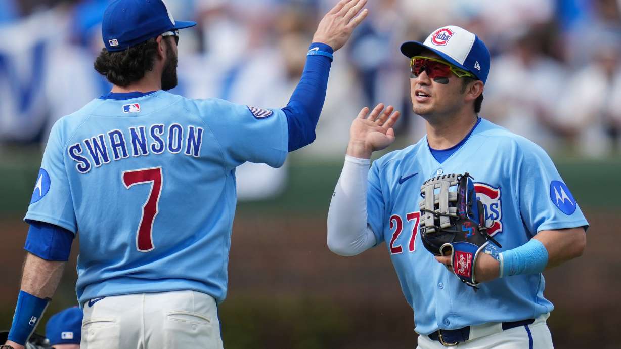 Chicago Cubs' Dansby Swanson (7) and Seiya Suzuki (27) celebrate their team's win over the New York Mets in a baseball game Friday, April 17, 2026, in Chicago.