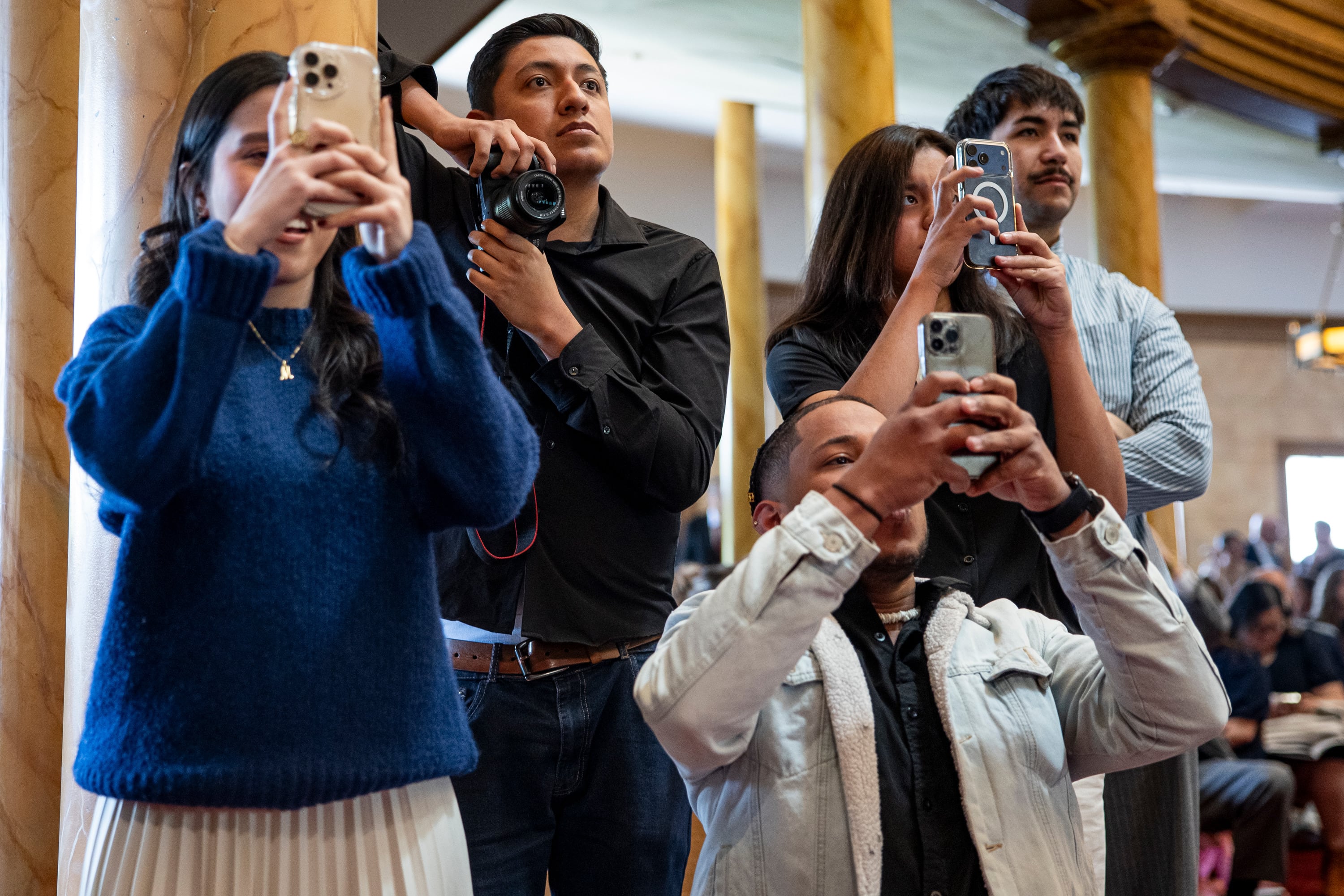Friends and family take photos as graduates walk across the stage as they receive their diplomas during the 139th Ensign College Commencement Exercises at the Salt Lake Tabernacle on Temple Square in Salt Lake City on Friday. The class was the largest in school history.