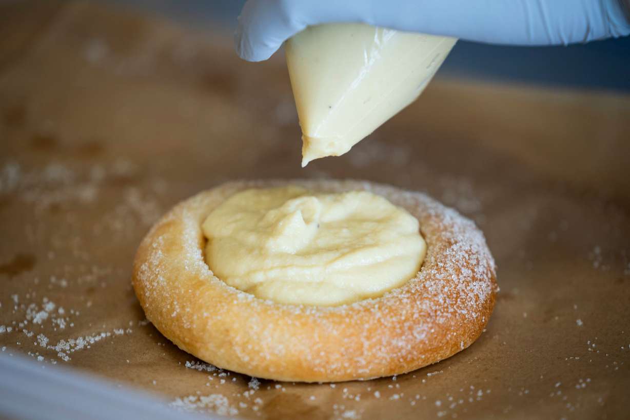 Alfred Kilis, co-owner of SVEA Scandinavian Kafé on Wheels, fills a sun bun with a house-made vanilla custard in his food truck in Eagle Mountain on April 10.