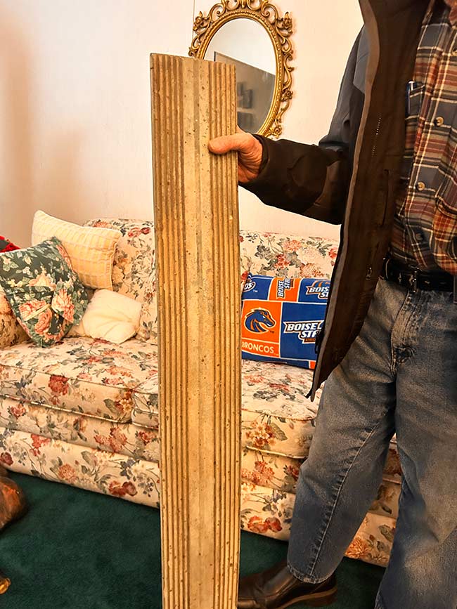 Virgil Jonak holds a board he took from the Teton Dam construction site at his home in Shelley, Idaho, Saturday. Jonak was a former truck driver for the construction site.