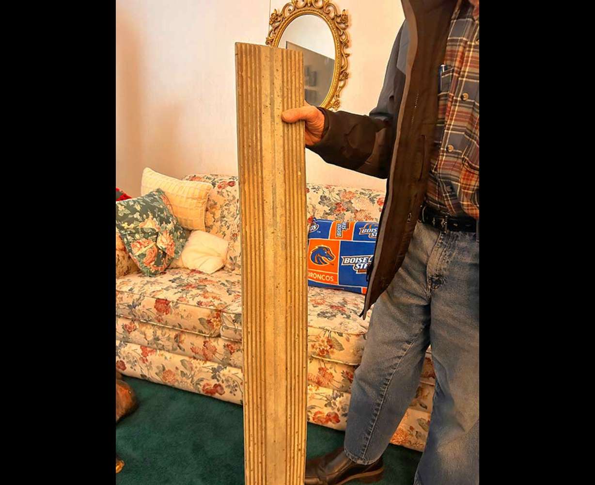 Virgil Jonak holds a board he took from the Teton Dam construction site at his home in Shelley, Idaho, Saturday. Jonak was a former truck driver for the construction site.