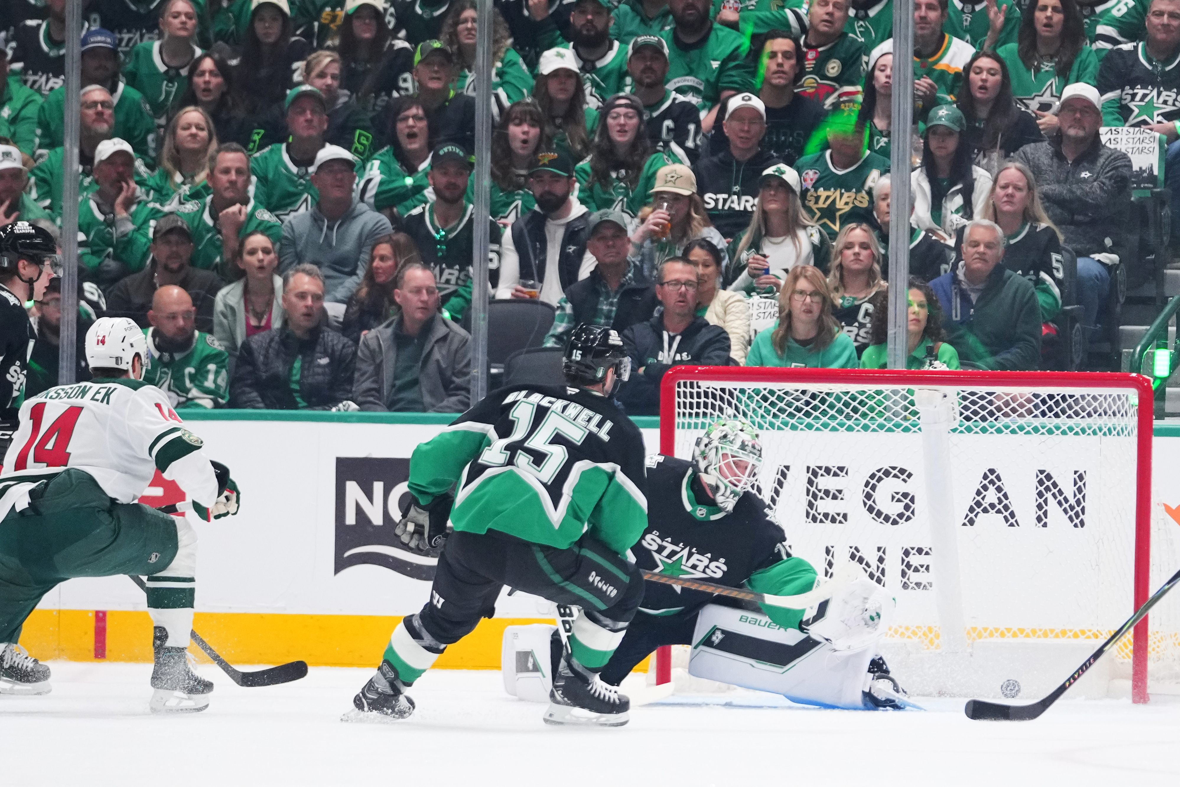 A shot by Minnesota Wild center Joel Eriksson Ek (14) enters the net of Dallas Stars goaltender Jake Oettinger, center, for a goal during the first period in Game 1 of a first-round NHL Stanley Cup playoffs hockey series, Saturday, April 18, 2026, in Dallas, Texas. 