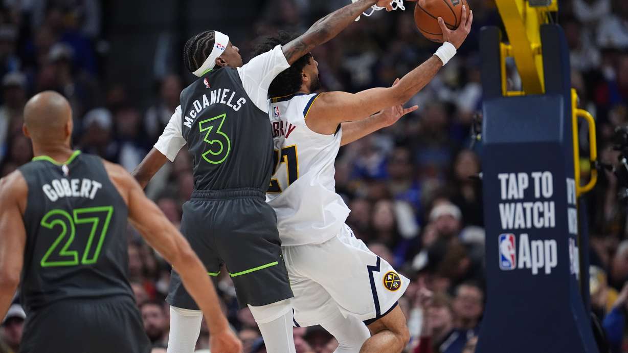 Minnesota Timberwolves forward Jaden McDaniels, left, tries to block a shot by Denver Nuggets guard Jamal Murray in the second half in Game 1 of a first-round NBA playoffs basketball series, Saturday, April 18, 2026, in Denver.