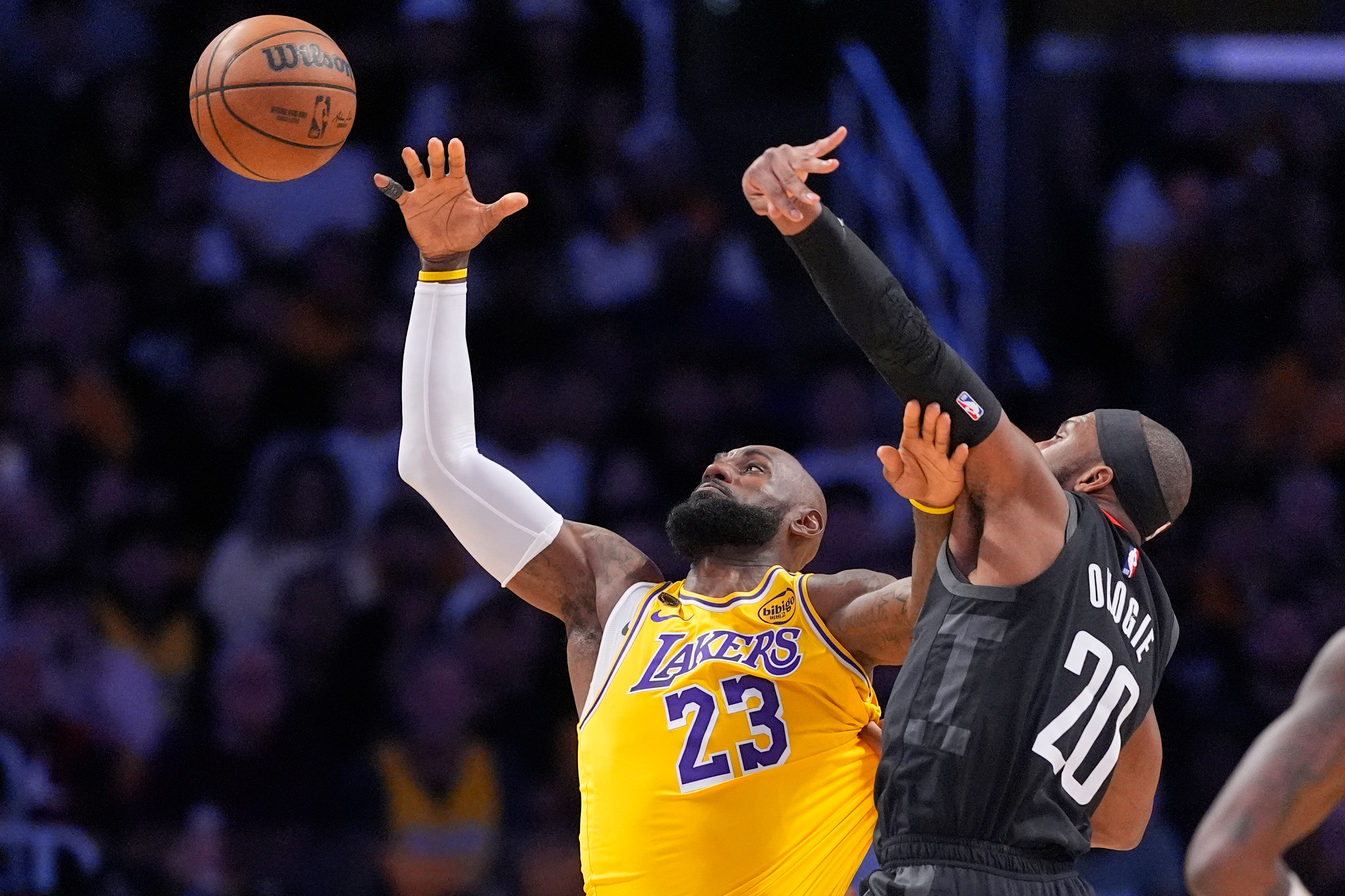 Los Angeles Lakers forward LeBron James, left, takes a pass as Houston Rockets guard Josh Okogie defends during the first half in Game 1 of a first-round NBA playoffs basketball series Saturday, April 18, 2026, in Los Angeles. 