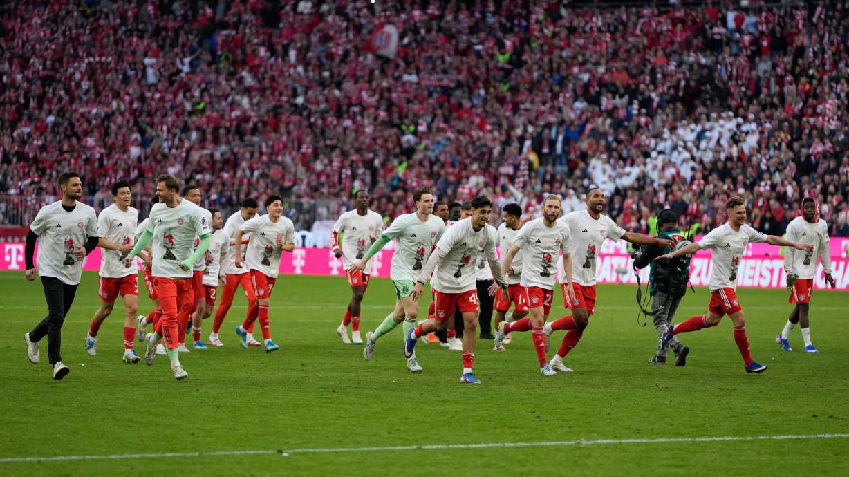 Bayern players celebrate after their team clinched the German league title after a Bundesliga soccer match between Bayern and Stuttgart in Munich, Germany, Sunday, April 19, 2026.