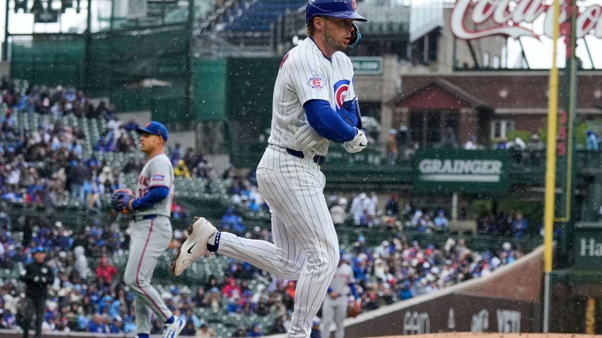 Chicago Cubs' Nico Hoerner, foreground, walks to first during the first inning of a baseball game against the New York Mets in Chicago, Sunday, April 19, 2026.
