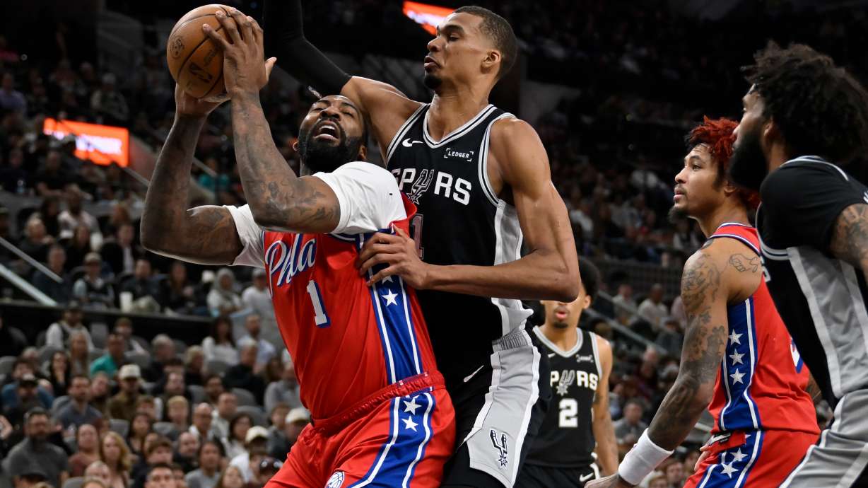 Philadelphia 76ers center Andre Drummond, left, tangles with San Antonio Spurs center Victor Wembanyama during the first half of an NBA basketball game, Monday, April 6, 2026, in San Antonio.