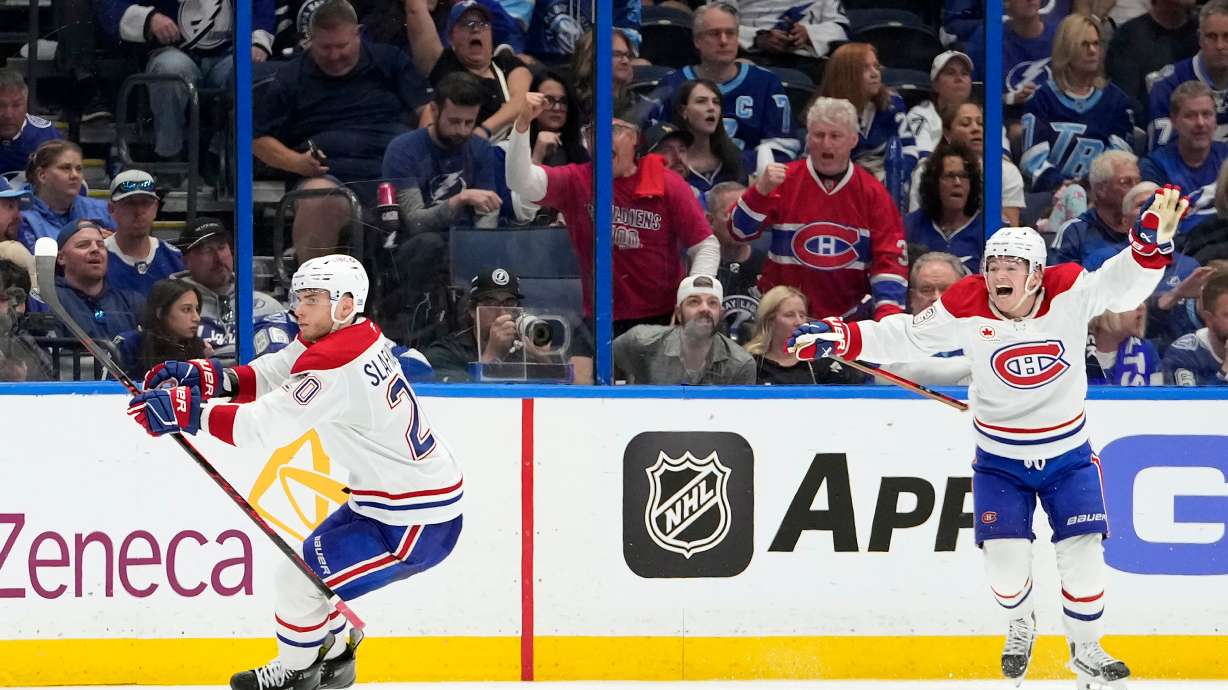 Montréal Canadiens left wing Juraj Slafkovský (20) celebrates his goal with right wing Cole Caufield against the Tampa Bay Lightning during overtime in Game 1 of an NHL hockey Stanley Cup first-round playoff series, Sunday, April 19, 2026, in Tampa, Fla.