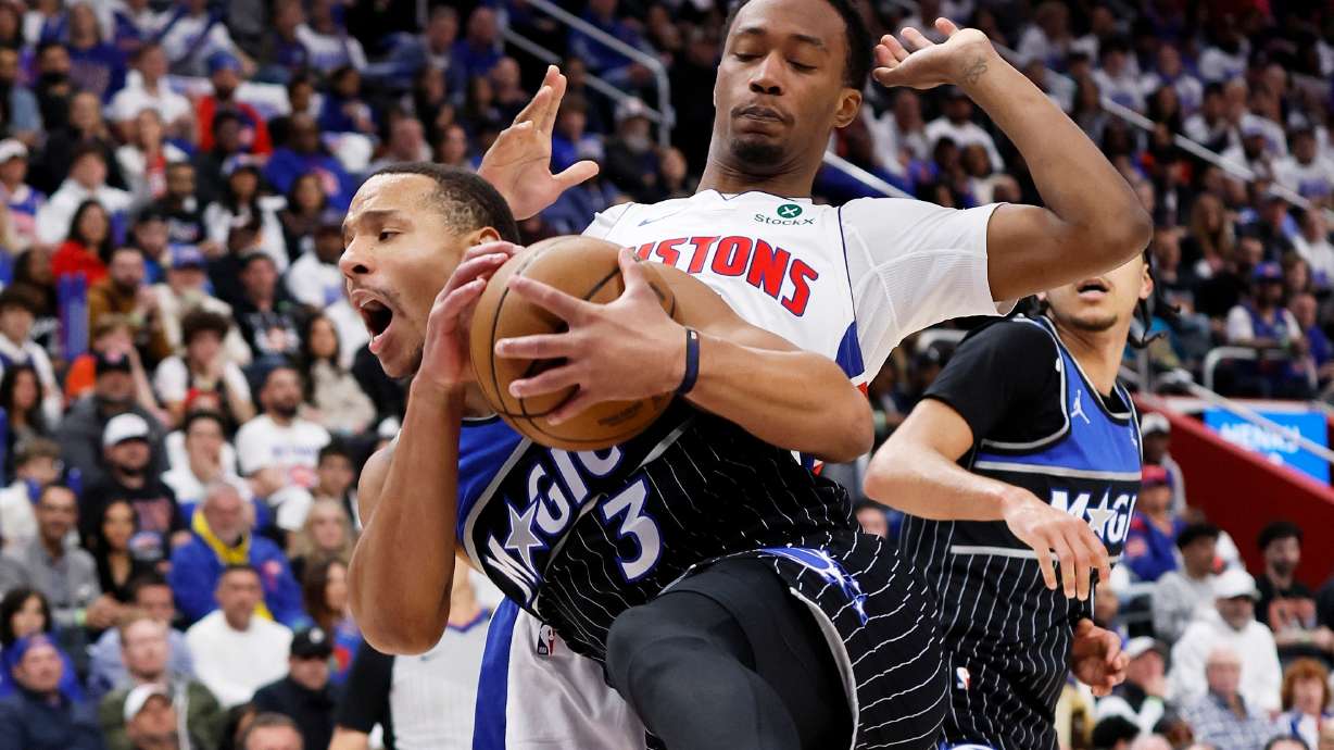 Orlando Magic guard Desmond Bane (3) grabs a rebound in front of Detroit Pistons forward Ronald Holland II, top right, during the first half in Game 1 of a first-round NBA basketball playoffs series Sunday, April 19, 2026, in Detroit.