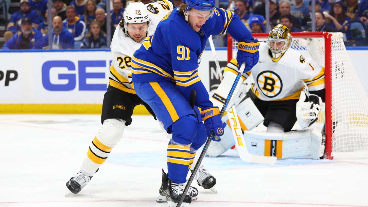 Buffalo Sabres right wing Josh Doan (91) carries the puck past Boston Bruins defenseman Andrew Peeke (26) during the first period in Game 1 of a first-round NHL hockey Stanley Cup playoff series Sunday, April 19, 2026, in Buffalo, N.Y.