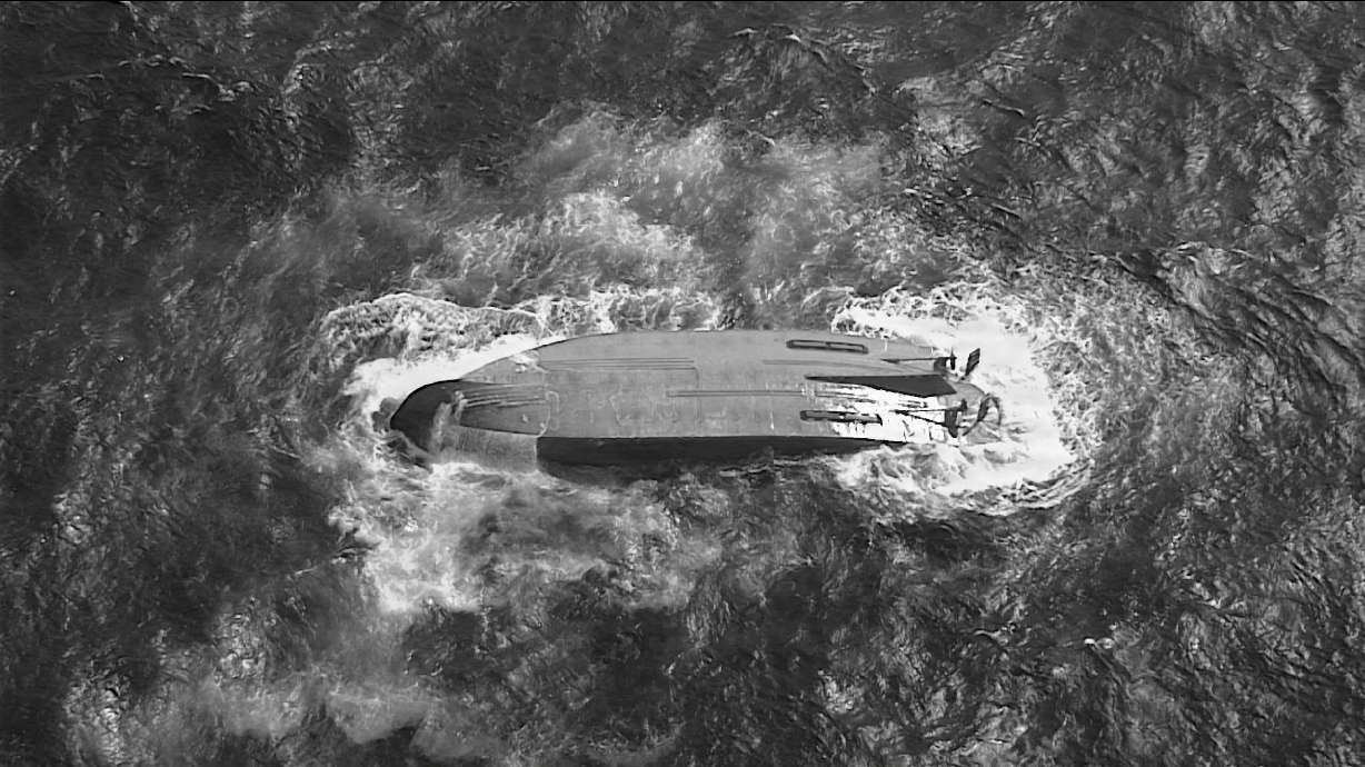 A U.S. Coast Guard HC-130 Hercules airplane crew assigned to Coast Guard Air Station Barbers Point flies over an overturned vessel offshore Saipan, Saturday, while searching for a missing vessel, the Mariana, that experienced an engine failure Wednesday.