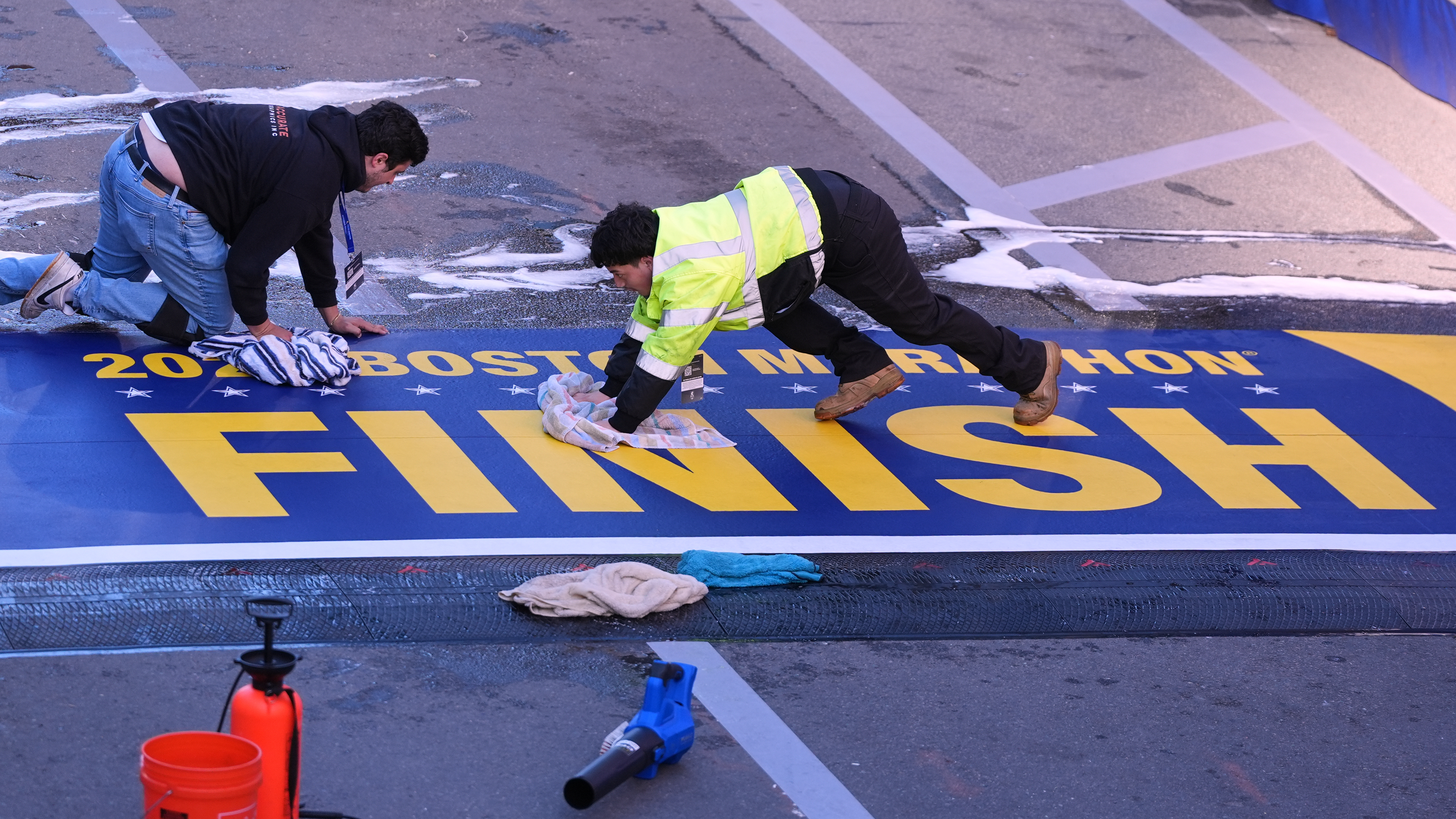 Workers scrub the finish line clean prior to the Boston Marathon, Monday, April 20, 2026, in Boston. 