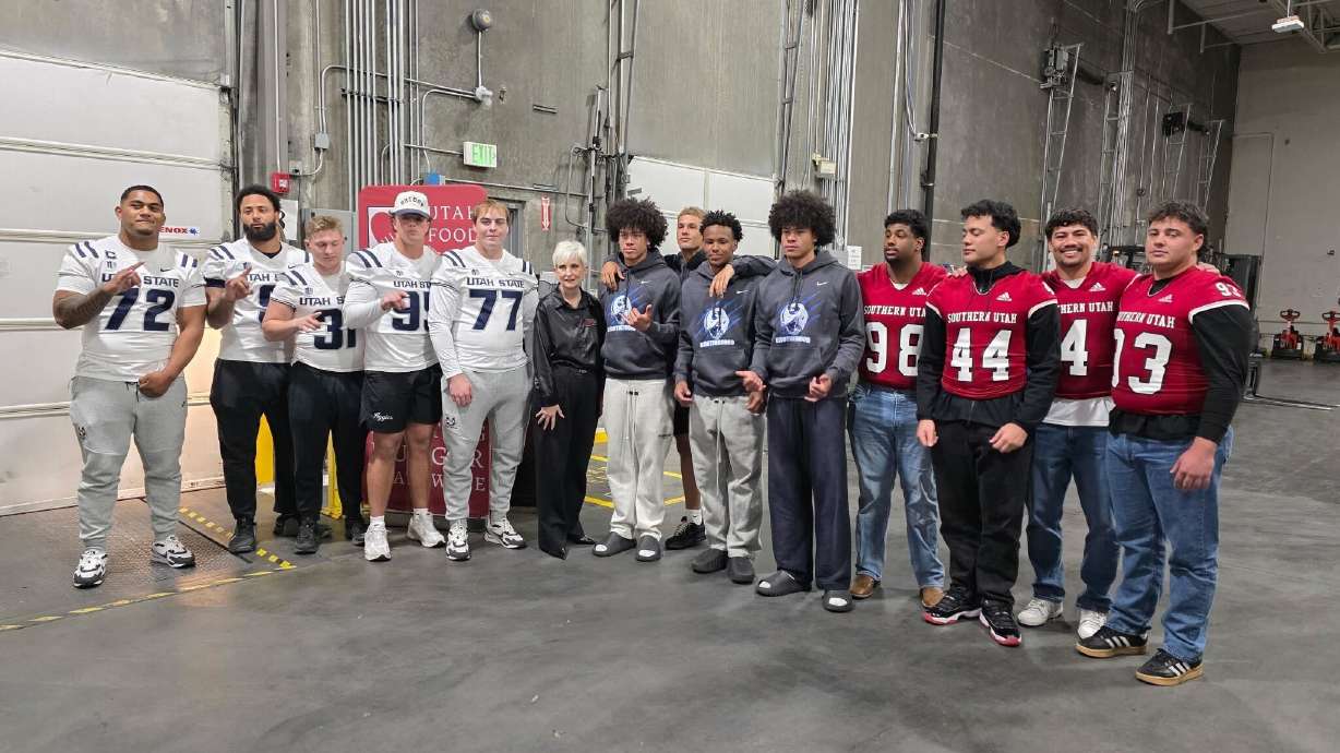 Players from Utah State University, Brigham Young University and Southern Utah University stand with Ginette Bott, president and CEO of the Utah Food Bank in South Salt Lake, after unloading 20,000 pounds of pork on Friday.