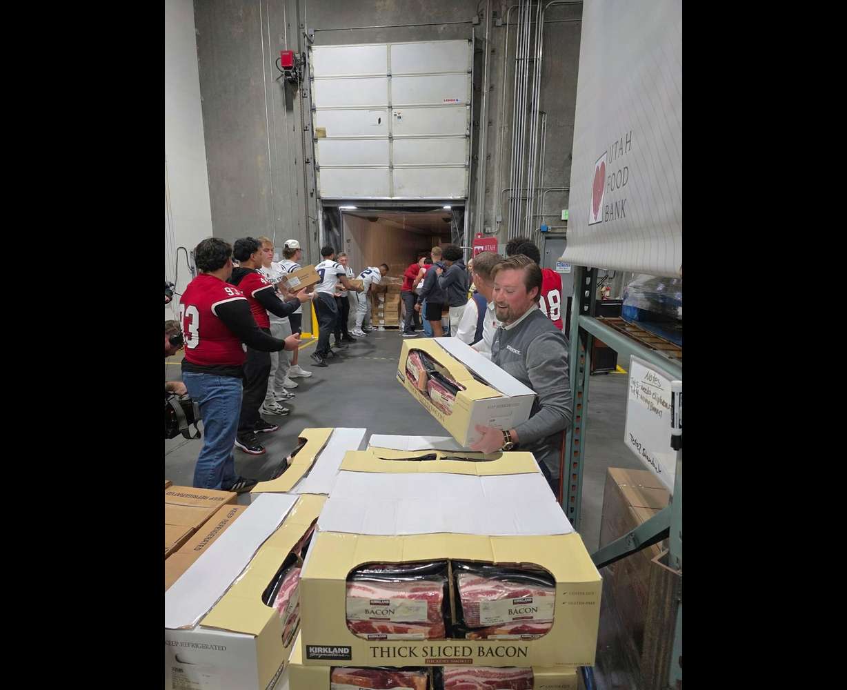 Football players from Utah State University, Brigham Young University and Southern Utah University worked together to pass boxes along an assembly line in the Utah Food Bank warehouse in South Salt Lake, Friday.