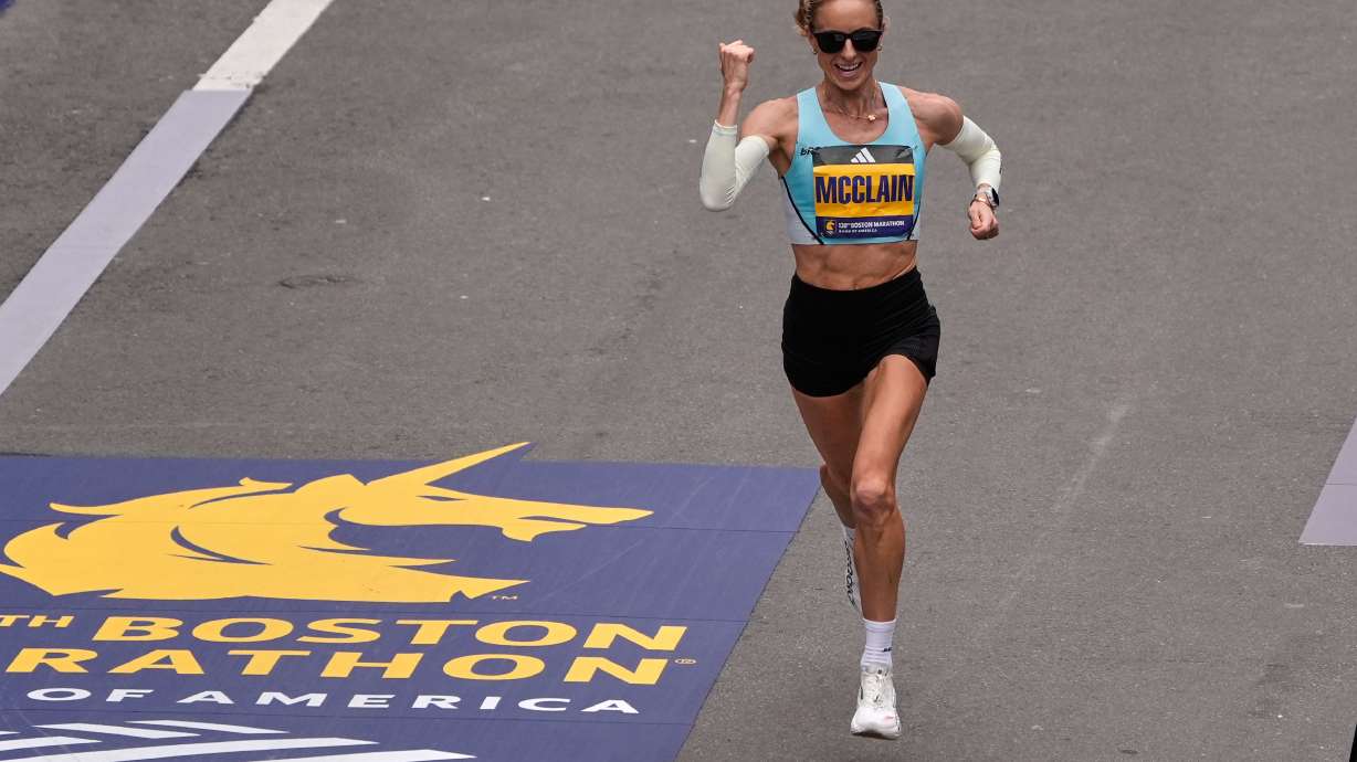 Jess McClain of Phoenix, the top American woman finisher, pumps her fist while approaching the finish line of the Boston Marathon, Monday, April 20, 2026, in Boston.