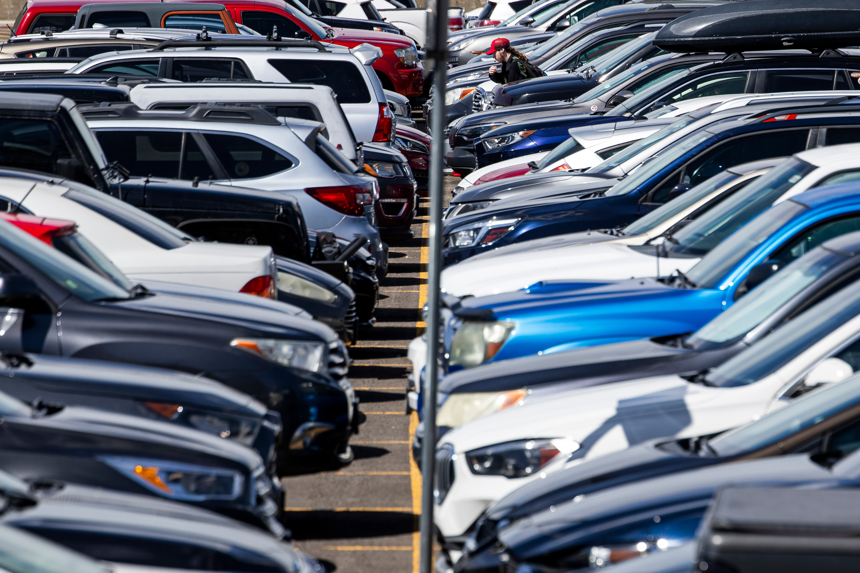 A student wanders through rows of cars as they walk to campus at the University of Utah in Salt Lake City on Monday. The U.'s Board of Trustees last week approved a bond measure to fund an underground parking structure that will add approximately 1,500 spaces to campus.