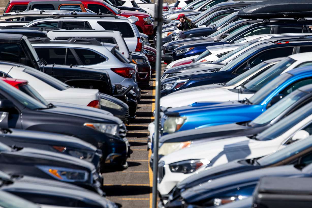 A student wanders through rows of cars as they walk to campus at the University of Utah in Salt Lake City on Monday. The U.'s Board of Trustees last week approved a bond measure to fund an underground parking structure that will add approximately 1,500 spaces to campus.