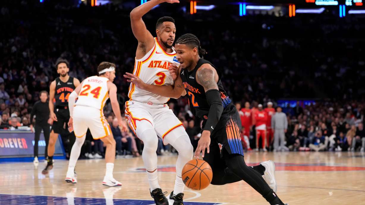 New York Knicks guard Miles McBride (2) drives past Atlanta Hawks guard CJ McCollum (3) during the first half in Game 2 of a first-round NBA playoffs basketball series, Monday, April 20, 2026, in New York.